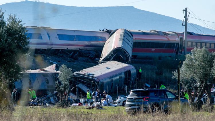 Emergency responders at the scene of a devastating train crash in Spain, with derailed cars and debris